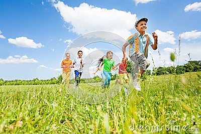 Happy kids playing and running in the field Stock Photo