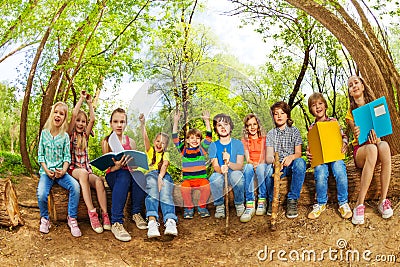 Happy kids reading books outdoor in summer camp Stock Photo