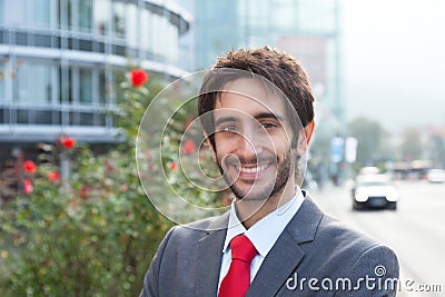 Happy latin businessman with beard in front of his office Stock Photo