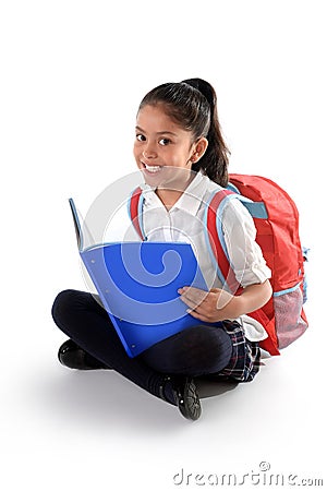 Happy latin child reading textbook or notepad smiling sitting on the floor Stock Photo