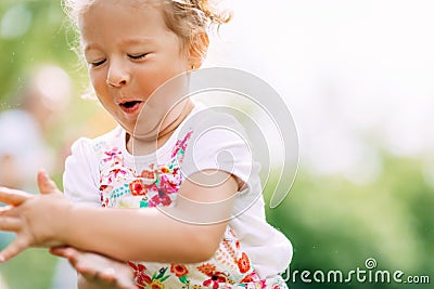 A happy laughing baby is running around the park or garden. Summer, summer time, happy days Stock Photo