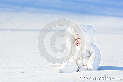 Happy laughing baby in snow on sunny winter day Stock Photo