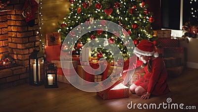 Happy laughing child girl with magic gift on Christmas Eve Stock Photo