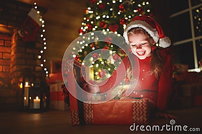 Happy laughing child girl with magic gift on Christmas Eve Stock Photo