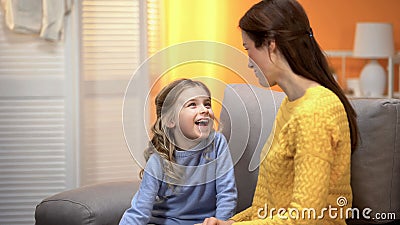 Happy laughing girl telling smiling mommy funny stories, trustful relations Stock Photo