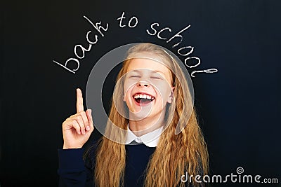 Happy laughing school child near school blackboard. Stock Photo