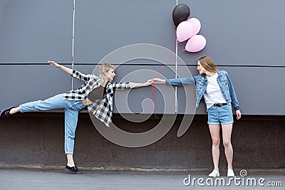 Happy lesbian couple holding hands with air balloons outdoors Stock Photo