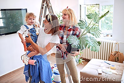 Lesbian couple women moving into new home and having fun with a toddler girl Stock Photo