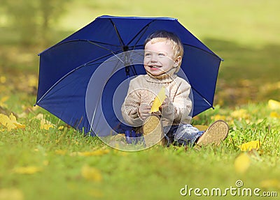 Happy little baby enjoying warm sunny autumn day in the park Stock Photo