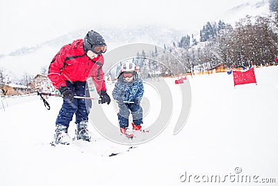 Happy little boy learning skiing with his father in Kitzbuhel ski resort, Tyrol, Austria Stock Photo