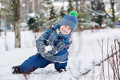 Happy little boy sculpts snowballs Stock Photo