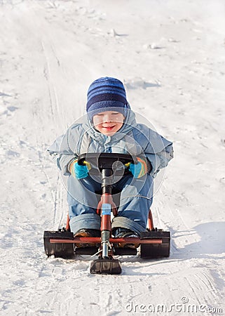 Happy little boy sledging at sleig Stock Photo