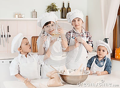 Happy little chefs preparing dough in the kitchen Stock Photo