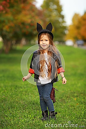 Happy little child posing for the camera, baby girl laughing and playing in the autumn on the nature walk outdoors. Stock Photo