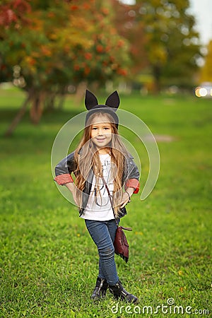 Happy little child posing for the camera, baby girl laughing and playing in the autumn on the nature walk outdoors. Stock Photo