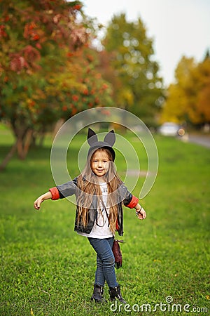 Happy little child posing for the camera, baby girl laughing and playing in the autumn on the nature walk outdoors. Stock Photo