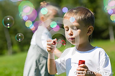 Happy little children blow soap bubbles Stock Photo