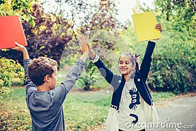 Happy little children celebrating success while giving high five Stock Photo