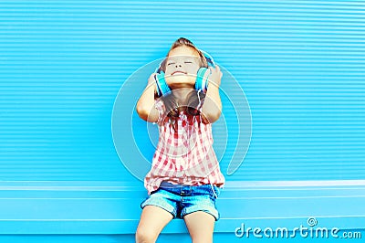 Happy little girl child listens to music in headphones Stock Photo