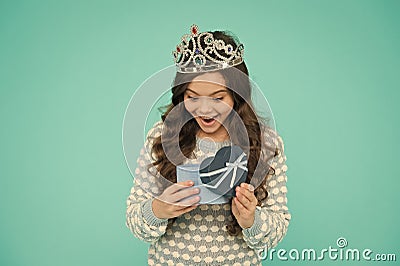Happy little girl in crown opening birthday present box. greeting child on holiday. congratulation. b-day girl Stock Photo