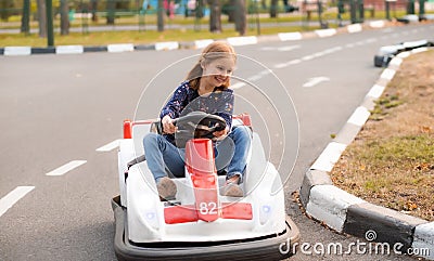 Happy little girl driving kart in park Stock Photo
