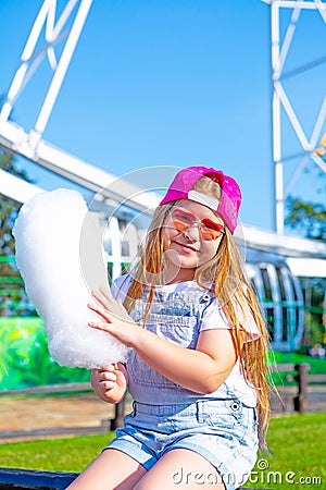 Happy little girl eating cotton candy Stock Photo