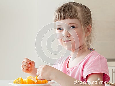 Happy little girl eating a tasty orange Stock Photo