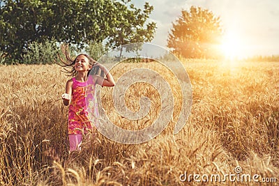 Happy little girl in a field of ripe wheat Stock Photo
