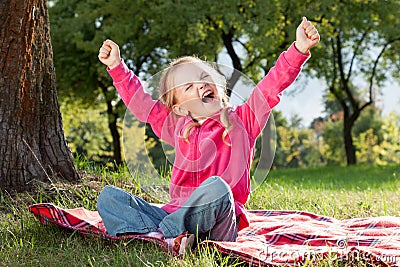 Happy little girl with hands up Stock Photo