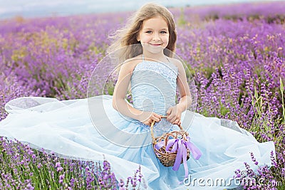 Happy little girl in lavender field with basket Stock Photo