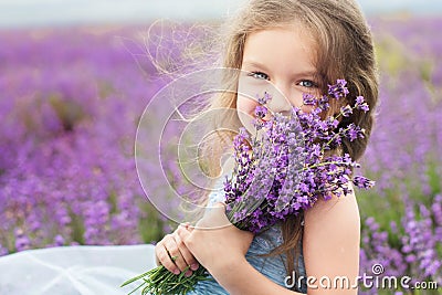Happy little girl in lavender field with bouquet Stock Photo