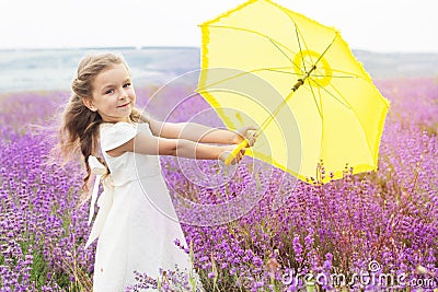 Happy little girl in lavender field with yellow Stock Photo