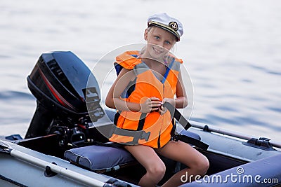 Happy little girl with life vests, having fun on a boat trip while on holiday in lake Stock Photo