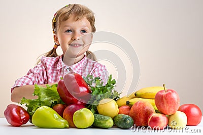 Happy little girl and a lot of fruit and vegetables. Stock Photo