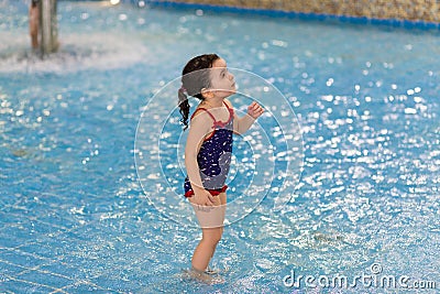 Happy little girl in the pool of the water park. Child learns to swim. teaching a child to swim Stock Photo