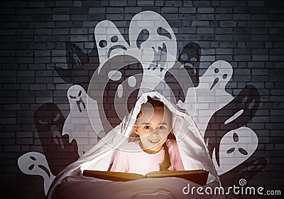 Happy little girl reading book in bed Stock Photo