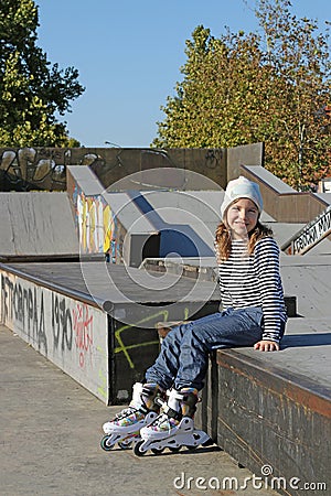 Happy little girl with rollerskates Stock Photo