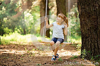 Happy Little girl on a swing in the park Stock Photo