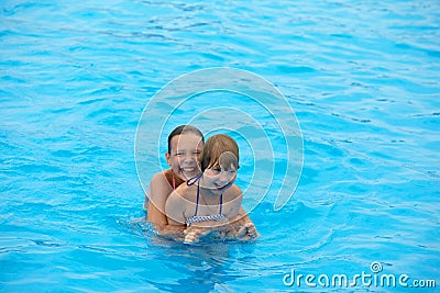 Happy little girls have fun swimming in the pool. Wonderful mood Stock Photo