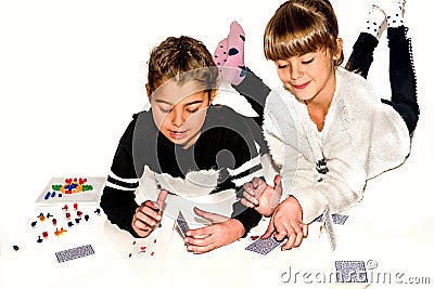 Happy little girls are making house of cards on white Stock Photo