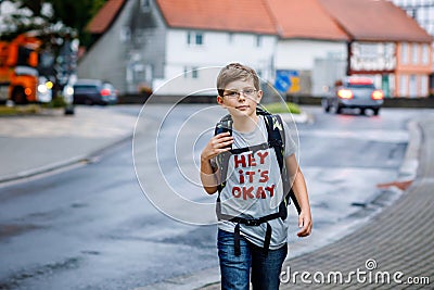 Happy little kid boy with glasses and backpack or satchel. Schoolkid on the way to middle or high school. Healthy Stock Photo
