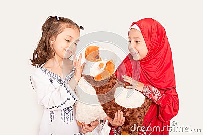 Happy little Muslim girls playing with sheep toy - celebrating E Stock Photo