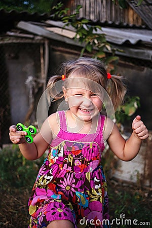 Happy little rural girl with a spinner in her hand Stock Photo