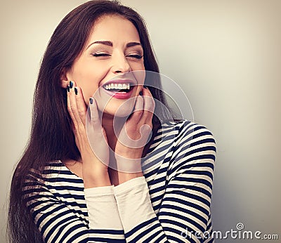 Happy loudly laughing woman holding hands the face Stock Photo