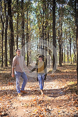 Happy love couple walking in forest and embracing, young family portrait, casual wear Stock Photo