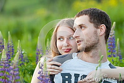 Happy loving couple hugging in field of lupine Stock Photo