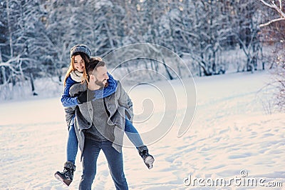 Happy loving couple walking in snowy winter forest, spending christmas vacation together. Outdoor seasonal activities. Stock Photo