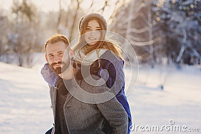 Happy loving couple walking in snowy winter forest, spending christmas vacation together. Outdoor seasonal activities. Stock Photo