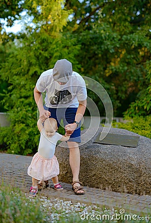 Happy loving family. Father and his daughter child girl playing and hugging outdoors. Cute little girl hugs daddy. Concept of Stock Photo