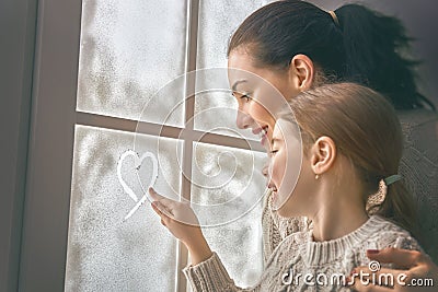 Family drawing a heart on frozen glass Stock Photo